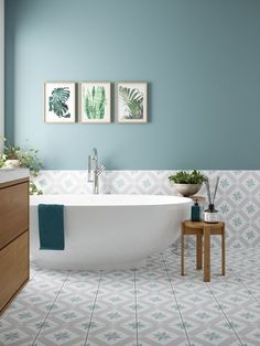 a bathroom with blue walls and tile flooring, including a bathtub in the center