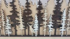 there are many different types of trees on the wall in front of each other and one is cut out from plywood