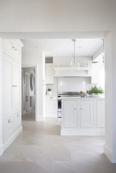 an empty kitchen with white cabinets and appliances