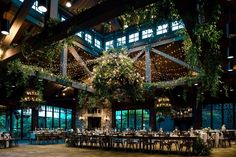 the inside of a building with tables and chairs set up for a formal function at night