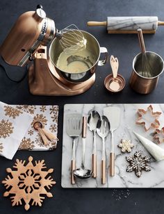 an assortment of kitchen utensils and decor on a counter top with snowflakes