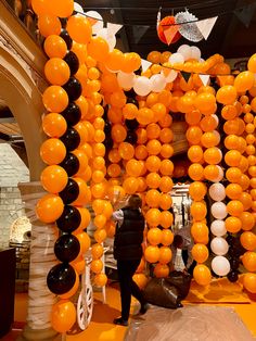 an orange, black and white balloon arch