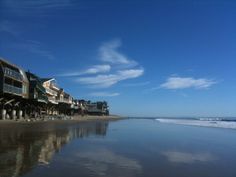 the beach is lined with houses and umbrellas