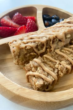 a wooden plate topped with fruit and granola bars