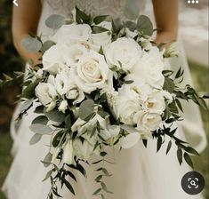 a bride holding a bouquet of white flowers