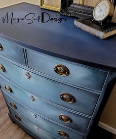 a blue dresser with an alarm clock on top