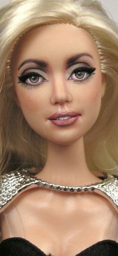 a close up of a barbie doll with blonde hair and black eyeliners on her face