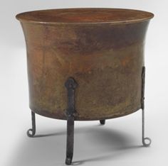 an old fashioned metal pot with iron legs