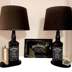 two lamps are sitting next to each other on a table with liquor bottles in front of them