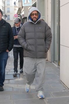 two men walking down the street in winter clothes