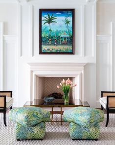 a living room filled with furniture and a painting on the wall over a fire place