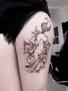 a woman's thigh with tattoos on it and an image of a fox in the background