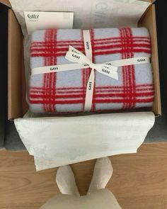 a box with two blankets wrapped in red and white plaid