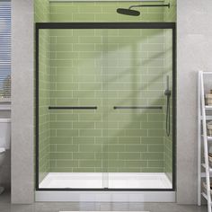 a bathroom with green tiles and a white toilet next to a walk - in shower