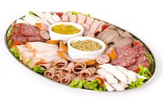 a platter filled with meats and condiments on white background stock photo