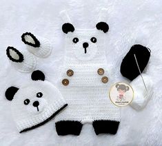 a crocheted panda bear outfit, hat and booties on a white blanket