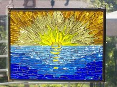 a stained glass window with the sun reflecting in it's blue and yellow colors