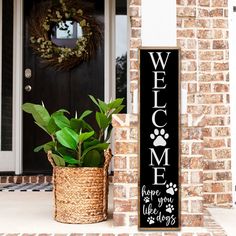 a welcome sign next to a potted plant