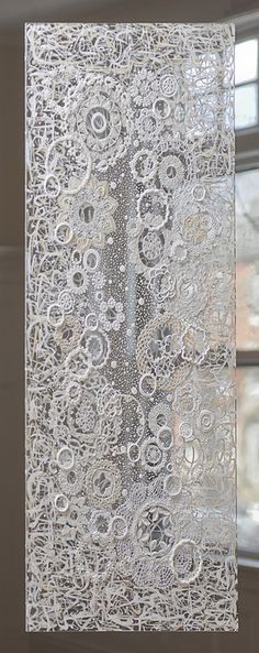 an intricate lace curtain hanging in front of a window