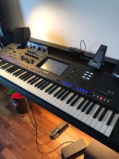 an electronic keyboard sitting on top of a hard wood floor