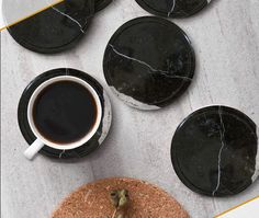 black marble coasters with coffee and olives on the side, next to each other