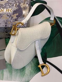 Description CHRSTN DR Saddle Bag White DYOR Oblique Embroidered Canvas Gold toned hardware For Women 25cm/10in CD Rep 1:1 Dimensions: 25.5 x 20 x 6.5 cm / 10 x 8 x 3 inches The iconic Saddle bag, crafted in white , is reimagined by Maria Grazia Chiuri. The legendary design is embellished with a DYOR Oblique perforations motif and features a Saddle flap with a magnetic ‘D’ stirrup clasp and an antique gold-finish metal ‘CD’ signature on either side of the strap. The bag has a wide embroidered str Christian Dior Saddle Bag, Louis Vuitton Shirt, Dior Oblique, Dior Saddle, Book Tote Bag, Embroidered Canvas, Maria Grazia, Luxury Products, Evening Clutch Bag