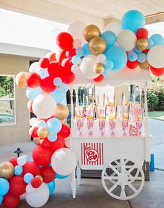 a popcorn cart decorated with balloons and streamers