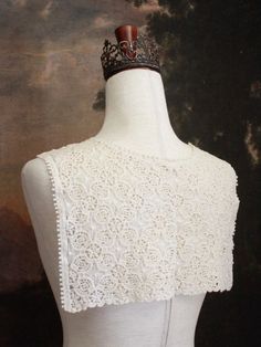 Warm up your historically inspired outfits during the colder months, with this Floral Crochet Folk Shawl / Capelet! Made from ornately patterned knit fabric, this piece can be worn tied around the shoulders, the waist, or simply left untied to drape off your shoulders. Truly a versatile piece that can compliment historical styles from any era!Also available in Black & White! Sizing: One SizeTie Length - 23 Inches / 57.5 CentimetersCape Length - 11 Inches / 27.5 CentimetersCape Width - 15 Inches / 37.5 Centimeters Materials:Cotton Weave Elegant Beige Crochet Top With Lace Trim, White Vintage Lace Crochet Top, Vintage White Lace Crochet Top, Elegant Cream Crochet Top With Crochet Trim, Elegant Cream Crochet Top With Lace Trim, Elegant Cream Crochet Top With Trim, Elegant Beige Crochet Top With Crochet Trim, Vintage Cream Lace Crochet Top, Vintage Cream Crochet Top With Trim