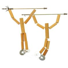 two pairs of wooden clothes pegs hanging from a metal bar with one pair attached to it