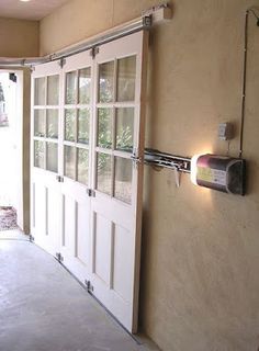 an empty room with two doors and a light on the wall above it that is lit up