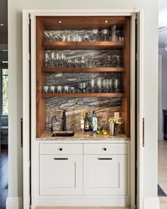 an open cabinet filled with glasses and bottles