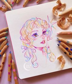 colored pencils are surrounding a drawing of a woman's face and her hair