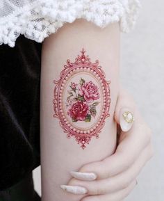 a woman's arm with a rose tattoo on the left side of her arm