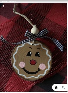 a wooden ornament with a smiling face on it's side hanging from a string