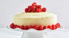 a white cake with raspberries on top