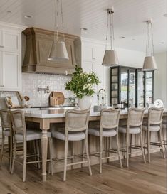 an instagram photo of a kitchen and dining room with chairs, counter tops, and cabinets