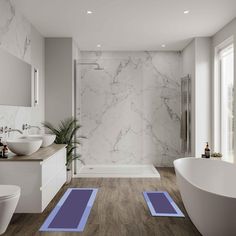 a bathroom with marble walls and wood flooring, two blue mats on the floor