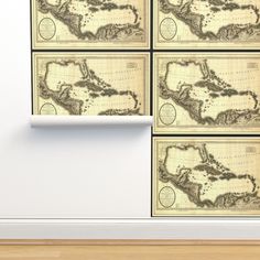 four maps are hanging on the wall in front of a white wall with wood flooring