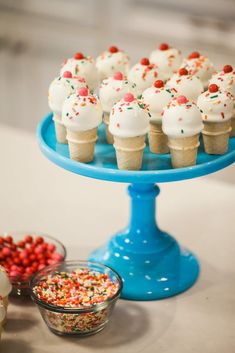 cupcakes on a blue cake stand with sprinkles and candies