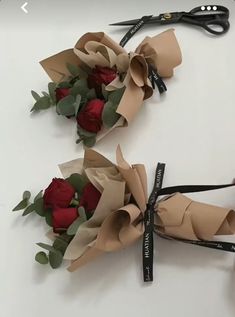 two bouquets of roses tied together with scissors