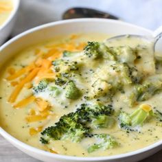 broccoli cheese soup in a white bowl with a spoon