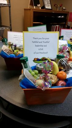 a table topped with baskets filled with fruits and vegetables next to a sign that says thank you for your food