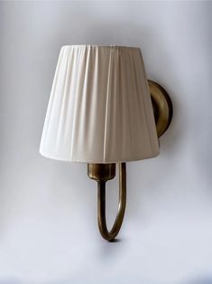 a wall lamp with a white shade on it