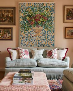 a living room filled with furniture and pictures on the wall above it's coffee table