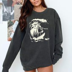 Surfer Ghoul Sweatshirt - Ride the Waves of Style This Halloween and Beyond! 🌊 Are you ready to catch some serious style this season? Dive into the spirit of Halloween with our Surfer Ghoul Sweatshirt, where the laid-back vibes of surfing meet the playful spookiness of the season! This isn't just any sweatshirt; it's your new go-to piece that combines comfort, uniqueness, and a whole lot of character. 🧵 Product Features: Premium Fabric: Made from 80% ring-spun cotton and 20% polyester, our swe Soft-washed Long Sleeve Sweatshirt For Streetwear, Long Sleeve Sweater With Screen Print In Relaxed Fit, Relaxed Fit Long Sleeve Sweater With Screen Print, Surfing Graphic Print Long Sleeve Hoodie, Band Merch Cotton Sweater, Oversized Band Merch Long Sleeve Sweatshirt, Grunge Long Sleeve Sweater With Graphic Print, Oversized Long Sleeve Band Merch Sweatshirt, Grunge Long Sleeve Cotton Sweatshirt