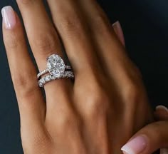 a woman's hand with two engagement rings on it