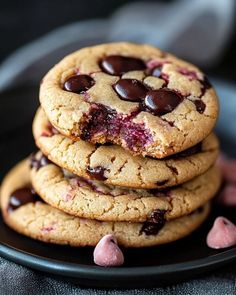 chocolate chip cookies stacked on top of each other with pink and white hearts around them