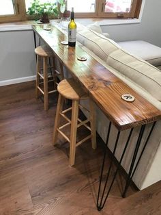 a table with two stools next to it and a bottle of wine on top