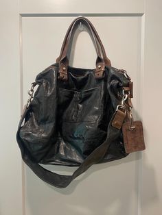 Only seen one more of these for sale! Lambskin leather large Chloe Bon Voyage tote bags, black with brown details and stitching. 5 zipper pockets (one internal) with zipper expansion on bottom of bag. Mix of gold and silver hardware, all original. Removable long strap included. Extremely good condition, minimal wear. Small smudge on Chloe tag, as seen.  Approx. Measures: 21" wide at bottom, 12" height. 7.5" drop on handles, 14" drop on shoulder strap. Never used since purchased at an auction! Insurance included $100, $200 international. Brown Leather-backed Tote Travel Bag, Brown Leather Trim Tote Travel Bag, Black Travel Satchel With Leather Lining, Brown Tote Travel Bag With Leather Trim, Brown Tote Travel Bag With Leather Backing, Black Satchel With Leather Trim For On-the-go, Black Satchel With Leather Trim Shoulder Bag, Black Satchel With Leather Trim As Shoulder Bag, Black Leather-lined Satchel For Travel