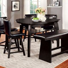 a dining room table with four chairs and a bench